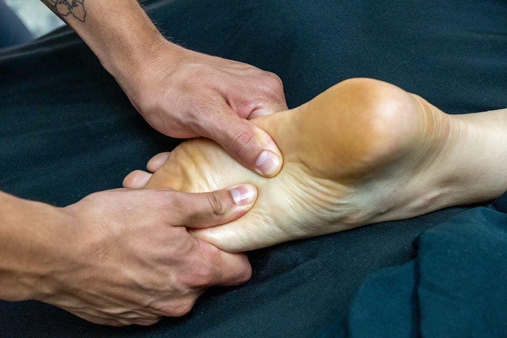Close-up of Isaac Clipper working the arch of a client's foot